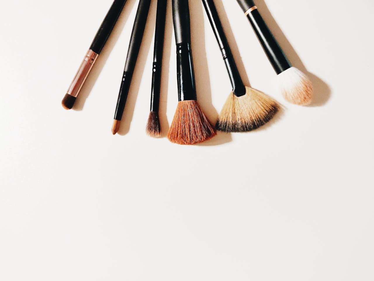A set of makeup brushes arranged on a white surface, perfect for beauty and cosmetic themes.
